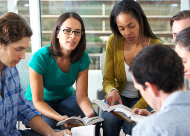 View of Language USA interpreters gathered in a circle reading.