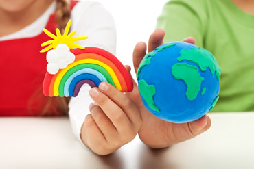 A child holds a rainbow while another child holds a globe, which represents Language USA's goal of diversity on campuses.