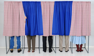 View of voters behind the curtains representing Language USA's goal to remove langauge barriers for voters.